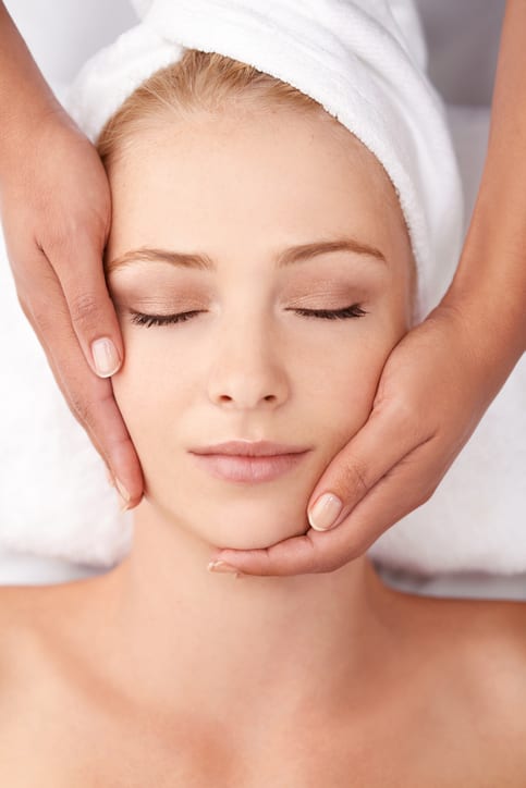 A beautiful young woman enjoying a neck massage at the spa